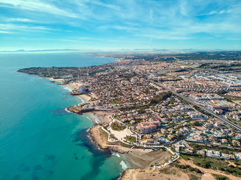 High angle view of townscape by sea against sky