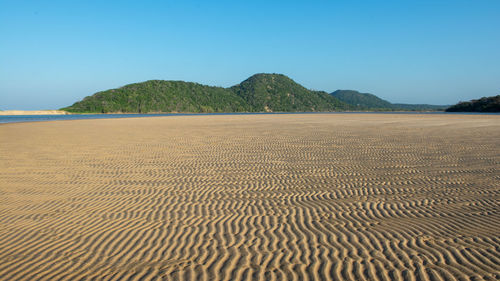 Scenic view of beach against clear blue sky