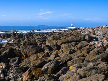 Rocks on beach against sky