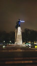 Illuminated lighthouse against sky at night