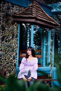 Portrait of a smiling young woman sitting outdoors