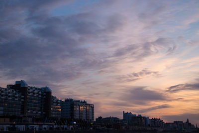 Buildings in city against cloudy sky