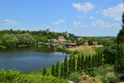 Scenic view of lake by buildings against sky