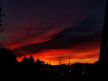 Silhouette street against dramatic sky during sunset