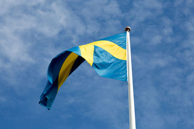 Low angle view of flag against blue sky