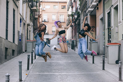 Portrait of friends jumping mid-air in outdoors