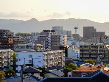 Buildings in city against sky during sunset