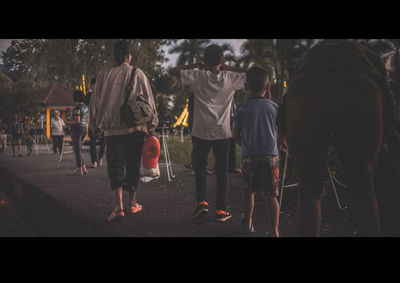 Rear view of people on street at night