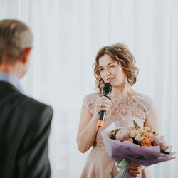 Young woman holding flower bouquet and microphone 