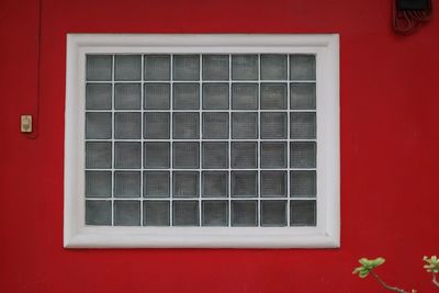 Close-up of window on red wall