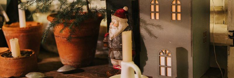 Christmas and new year time. home decor - candles, little fir christmas tree, figure of santa claus