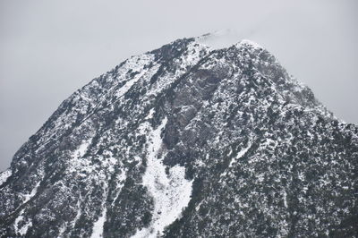 Low angle view of snow covered mountain against sky