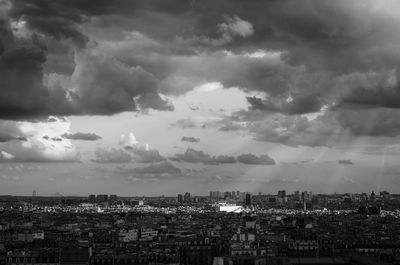 Aerial view of cityscape against storm clouds