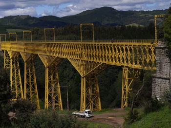 Scenic view of bridge over mountains against sky