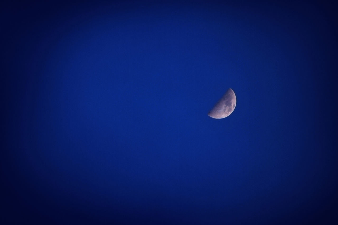LOW ANGLE VIEW OF MOON AGAINST BLUE SKY