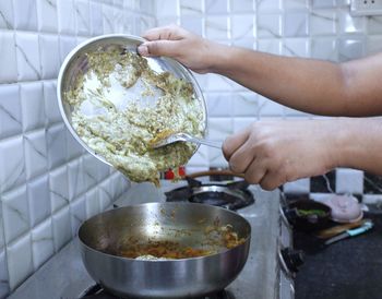 Midsection of person preparing food in kitchen at home