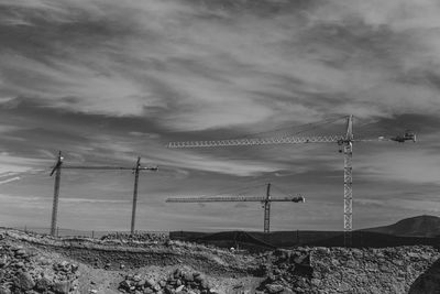 Electricity pylon on land against sky