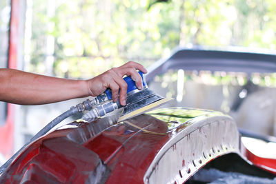 Painter polishes the car body to make the paint.