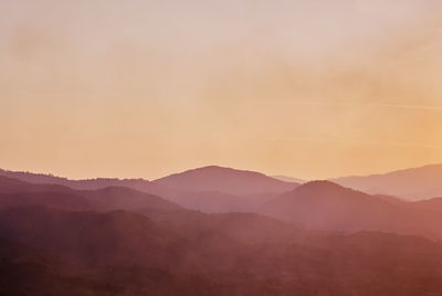 Scenic view of silhouette mountains against sky at sunset