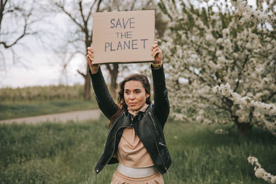 Eco-activist female holding placard with save the planet. recycling.