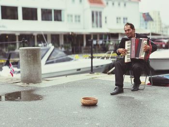 Full length of man sitting in city