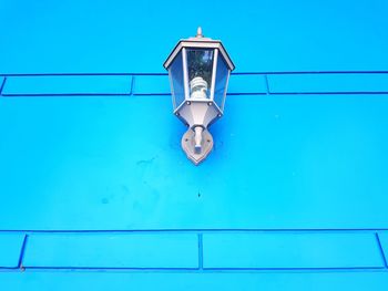 Low angle view of electric lamp against blue sky