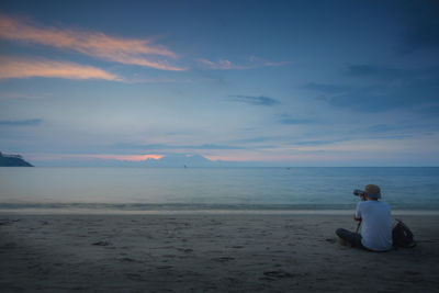 Rear view of a woman sitting on beach