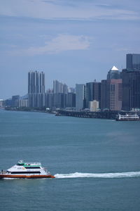 Sea by buildings against sky in city