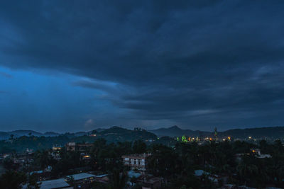 Houses in town against sky at night