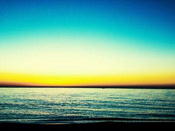Scenic view of sea against clear sky at sunset