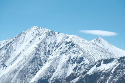 Scenic view of snowcapped mountains against clear blue sky