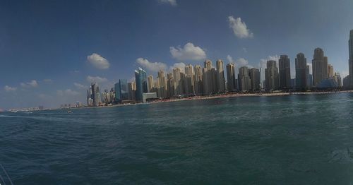 Panoramic view of sea and buildings against sky