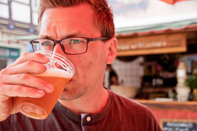 Close-up of young man drinking beer outdoors