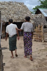 Rear view of people walking against building