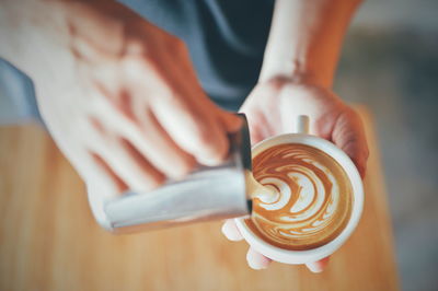 Cropped image of hand holding coffee cup