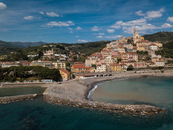 Buildings by sea against sky