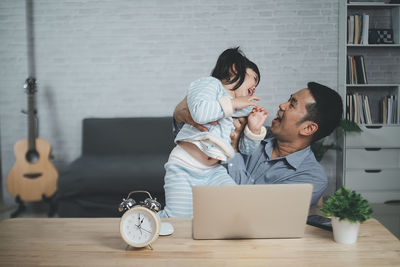 Cute daughter playing with father at home