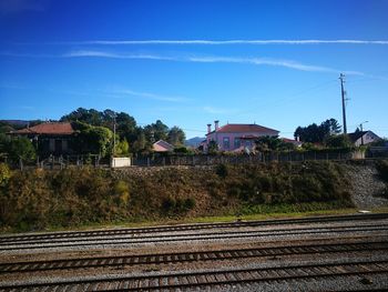 Railroad tracks by trees against sky