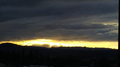 Scenic view of silhouette mountains against sky at sunset