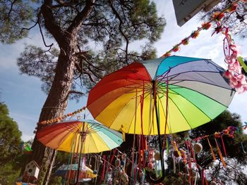 Low angle view of multi colored umbrellas against sky