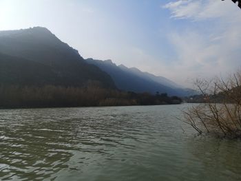 Scenic view of lake by mountain against sky