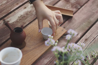 High angle view of hand holding tea cup on table