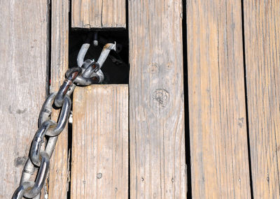Close-up chain connected to wooden floor