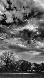 View of bare trees against cloudy sky