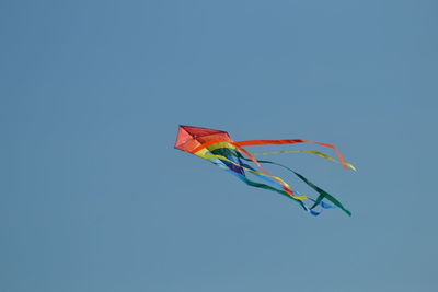 Low angle view of kite against clear blue sky