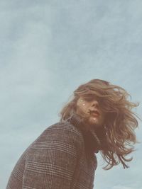 Low angle view of woman looking away against sky