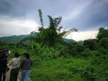 Rear view of people on mountain against sky