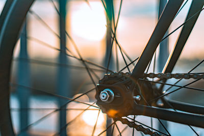 Close-up of bicycle wheel against sky during sunset