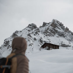 Person on snowcapped mountain against clear sky