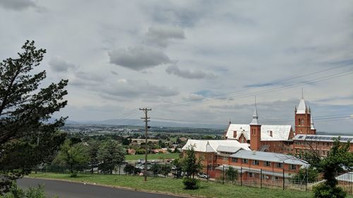 Houses by trees against sky